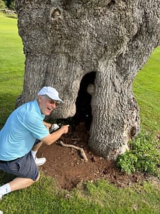 Gordon Wood retrieves his ball from a hollow tree