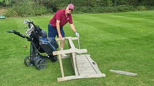 Colin Dunkerley picks up the bench his trolley had overturned