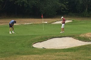 Clive Penwarden (SEH) putts out on the 18th. John Uwins records the score